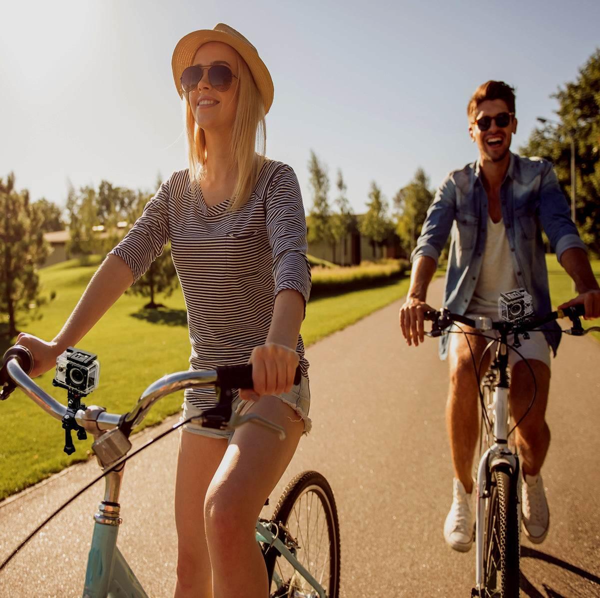 Couple riding bikes outdoors with 4K waterproof action camera mounted on handlebars