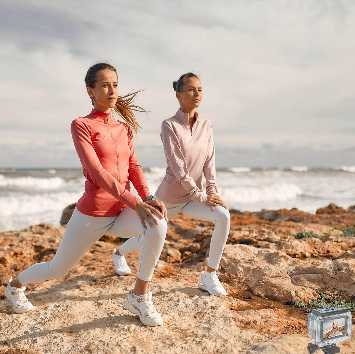 4K waterproof action camera capturing two women stretching on rocky beach near ocean