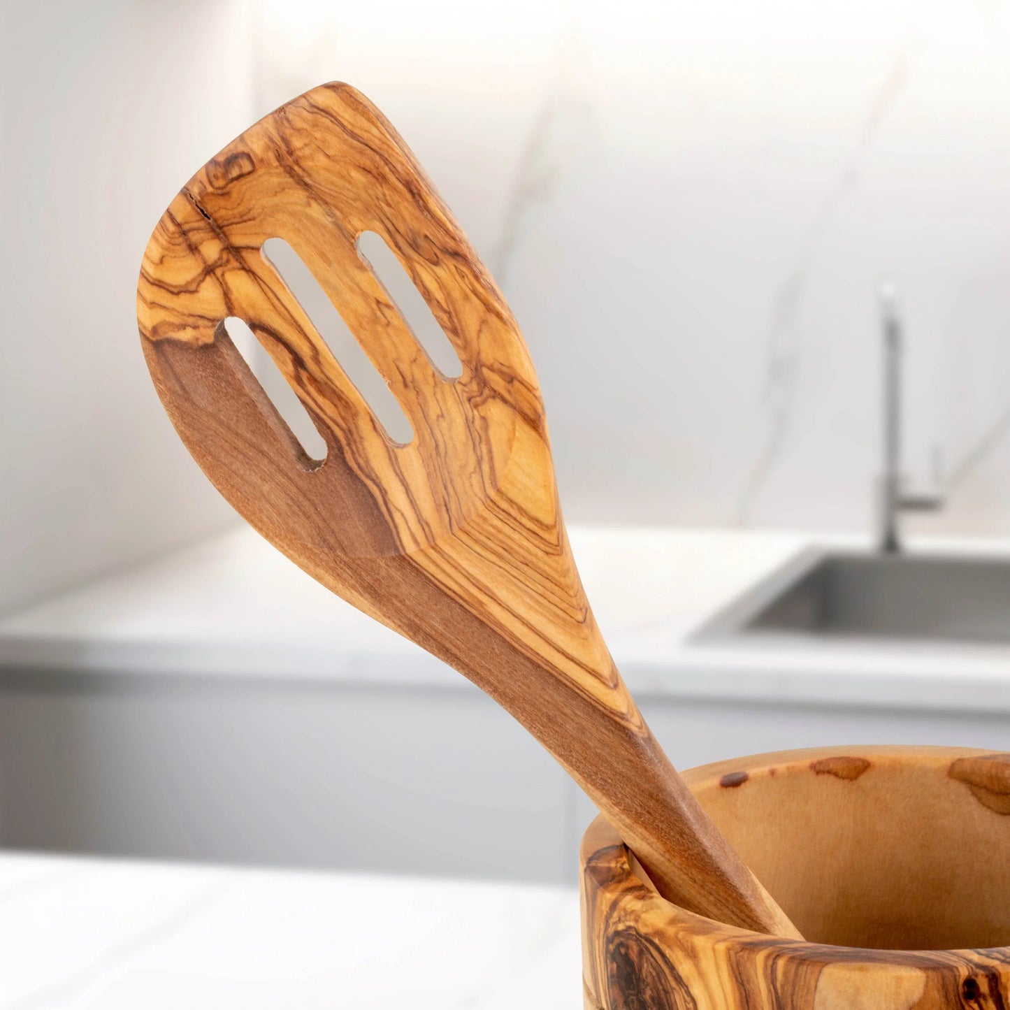 Handmade olive wood kitchen utensils slotted spatula by Turquoise Lucy in modern kitchen setting