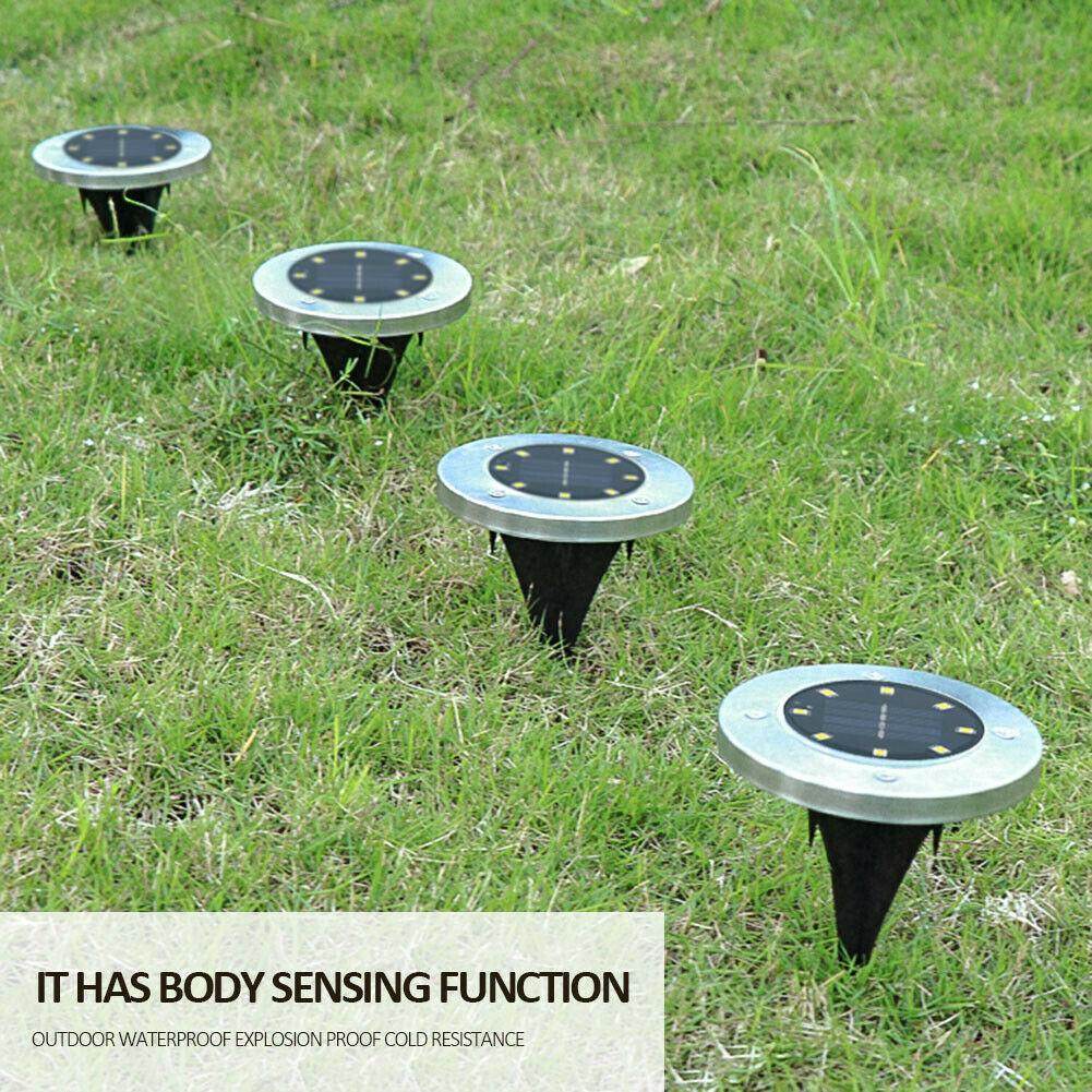 Pink Iolaus solar powered garden pathway lights with body sensing function placed on grassy lawn