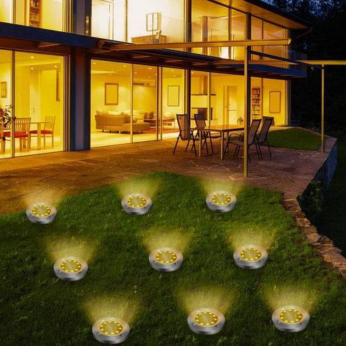 Pink Iolaus solar powered garden pathway lights illuminating outdoor patio and lawn at night