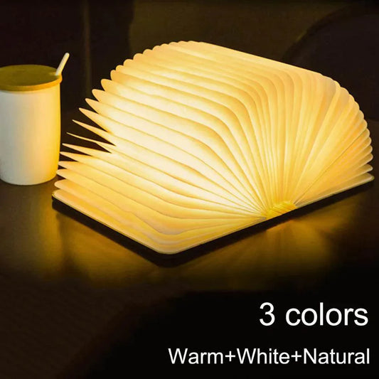 Yellow Pandora ambient bookshelf decor light glowing warm on a dark surface with cup beside